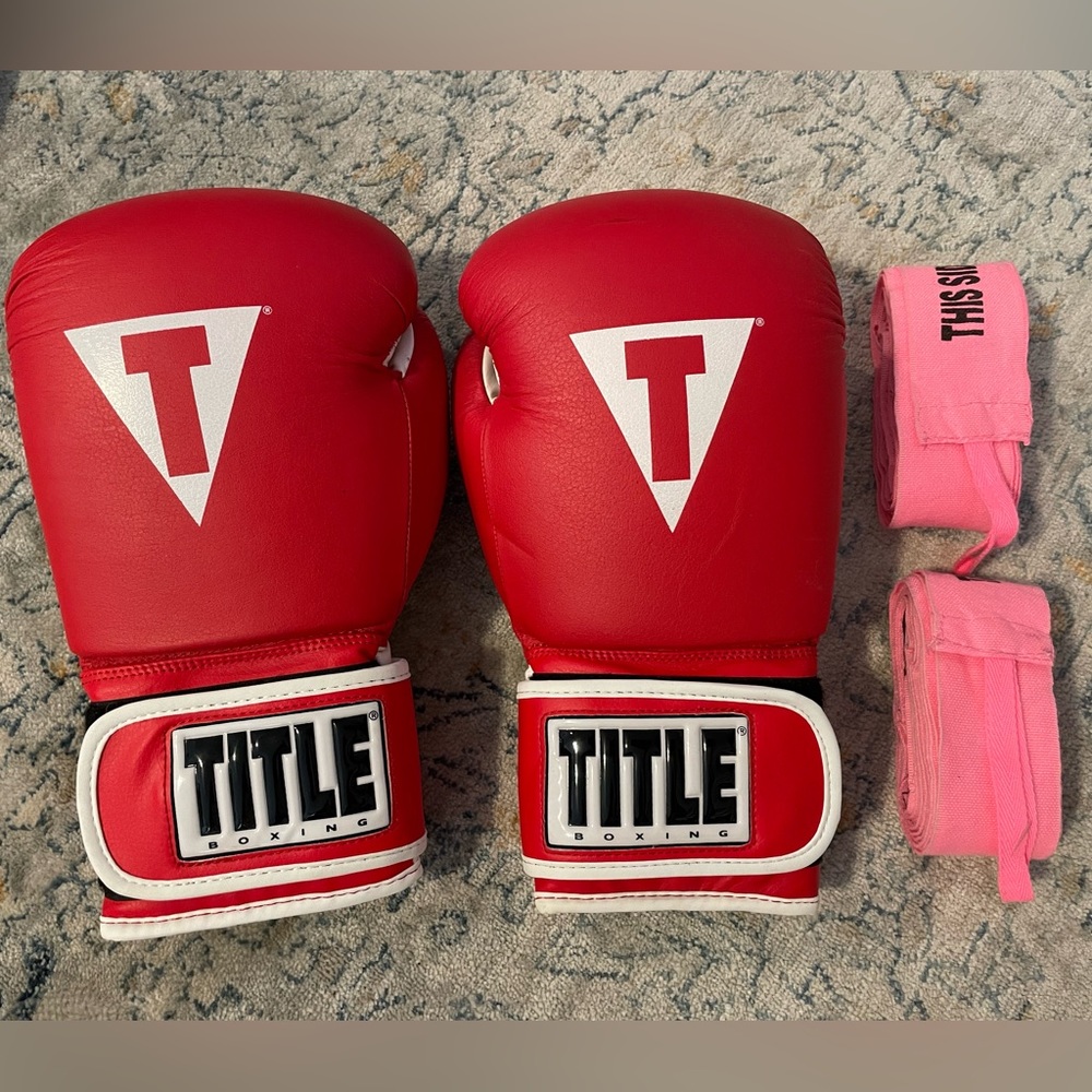 Red and white boxing gloves with hand wraps